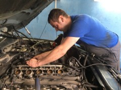 На фото механик Петров Виктор за ремонтом автомобиля BMW E60